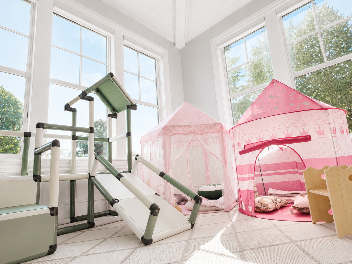 Sun-filled sunroom with a small indoor slide and pink play tents for cozy movement and imaginative play